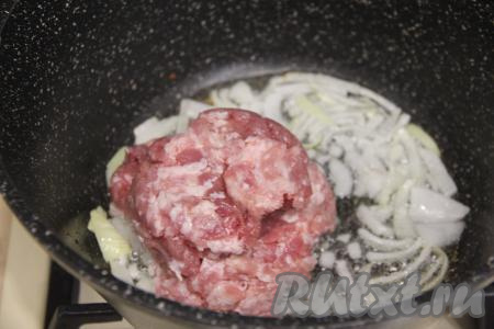 К обжаренному луку выложить фарш, тщательно перемешать.