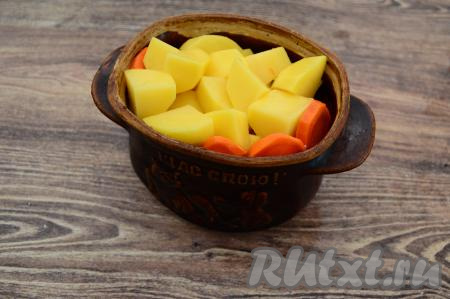 Картошку с морковкой разложить по горшочкам поверх куриных ножек. В каждый горшочек влить примерно 100 миллилитров горячей воды (я обычно заливаю горшочки водой примерно на 3/4 объёма).