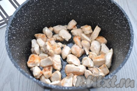 Обжариваем кусочки куриного мяса на огне выше среднего, периодически перемешивая, до появления на филе лёгкой румяной корочки со всех сторон.