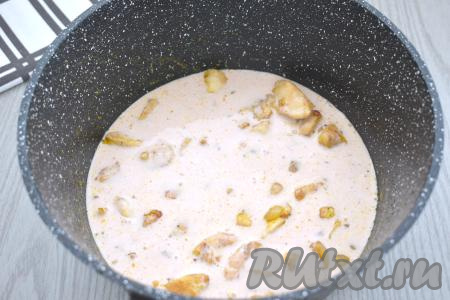 В отдельную ёмкость вливаем сливки и 150 миллилитров тёплой воды, добавляем томатный соус, по вкусу солим, тщательно перемешиваем венчиком. Получившийся сливочно-томатный соус вливаем к обжаренным кусочкам куриного филе. Перемешиваем, доводим соус до кипения.