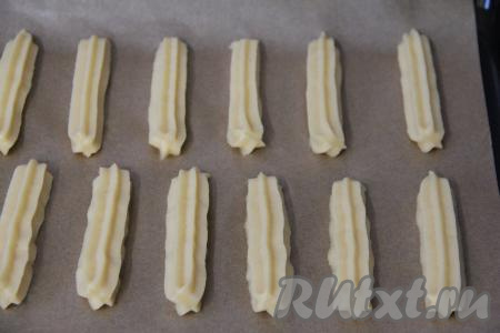 Противень застелить пергаментом. Отсадить эклеры на противень на небольшом расстоянии друг от друга.