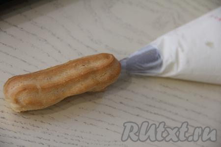 Заполнить эклеры кремом. Очень удобно кулинарным мешком с длинной насадкой наполнять эклеры кремом из рикотты. Если нет кулинарного мешка с такой насадкой, тогда можно сделать острым ножом на эклере сбоку надрез и наполнить его кремом.