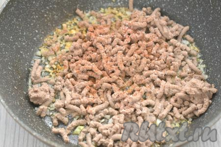 К обжаренному луку добавляем перекрученную варёную куриную печень, по вкусу солим, посыпаем специями (я использовала чёрный молотый перец и паприку), перемешиваем, обжариваем 5 минут, иногда помешивая.