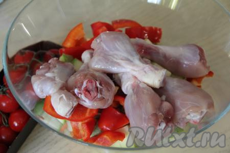В миску с нарезанными овощами выложить куриные ножки.