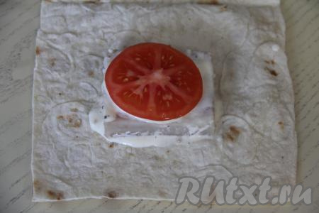 Помидор нарезать на кружочки. Выложить кружок помидора на рыбку.