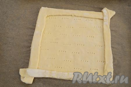 При помощи вилки наколоть дно будущего пирога. Дно пирога накалывается для того, чтобы слоёное тесто не сильно поднималось во время выпечки.