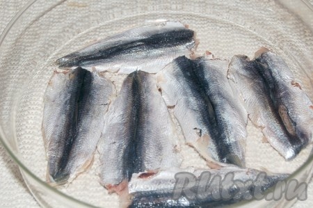 Часть очищенной салаки выложить в один слой в ёмкость, пересыпать солью, сверху выложить следующий слой рыбы, тоже пересыпать солью. Продолжая чередовать слои салаки с солью, выложить всю рыбку. В таком виде оставить на 1 час при комнатной температуре.
