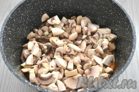 Шампиньоны моем, нарезаем на небольшие кусочки. К протушившимся свиным рёбрышкам добавляем грибы, солим, перемешиваем и готовим 5 минут.