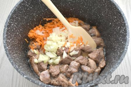 Лук и морковку очищаем. К мясу утки, обжаренному в течение 10 минут, добавляем мелко нарезанный лук и натёртую на крупной тёрке морковь.