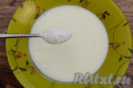 Пока взбиваются яйца, нужно в глубокую тарелку влить кефир. Желательно, чтобы кефир был комнатной температуры. В кефир всыпать соду, перемешать и оставить на 3-5 минут. Я подогреваю кефир в микроволновке в течение 20 секунд. Но можно и заранее достать кефир из холодильника, чтобы он постоял при комнатной температуре и согрелся. 