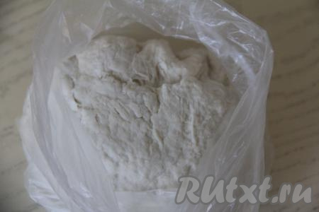 Перемешать тесто ложкой. Затем частями начать подсыпать оставшуюся муку, каждый раз полностью вмешивая её. После того как тесто будет сложно перемешивать ложкой, продолжайте замешивать его руками. Тесто должно получиться очень мягким, не забитым мукой, слегка липким. Как только тесто стало нужной консистенции, больше муку не добавляйте. Поместить тесто в целлофановый пакет и оставить на кухонном столе на 20 минут.