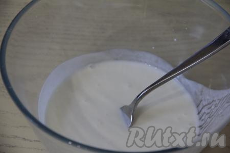 Сперва замесим тесто. Для этого кефир нужно подогреть до комнатной температуры. Я подогреваю кефир в течение 30 секунд в микроволновке, а затем перемешиваю. Но можно и просто заранее достать кефир из холодильника, чтобы он согрелся. В глубокую миску влить кефир комнатной температуры, всыпать соду, перемешать и оставить на 5 минут. За это время кефир вступит в реакцию с содой, на поверхности образуются пузырьки, а сам кефир немного увеличится в объёме.