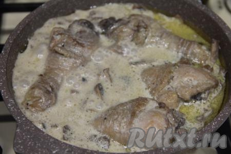 Дать сливкам закипеть и, уменьшив огонь до минимума, накрыть сковороду крышкой, тушить кусочки курицы с грибами минут 10. В процессе томления блюдо можно 1-2 раза перемешать, чтобы мясо равномерно пропиталось соусом из сливок.