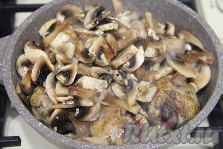 Шампиньоны нарезать на пластинки (если будете готовить с лесными грибами, тогда после отваривания крупные грибочки нужно будет нарезать на кусочки), добавить в сковороду с обжаренными куриными ножками, перемешать, убавить огонь до минимума. Накрыть сковороду крышкой.