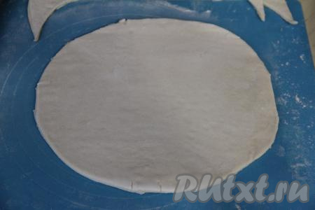 Срезать уголки раскатанного теста, сформировав круглый пласт.