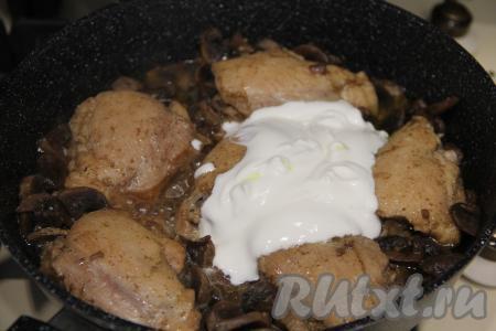 Жарить курицу с грибами в течение 20 минут на небольшом огне под крышкой, периодически перемешивая. Добавить сметану, можно немного подсолить, перемешать.