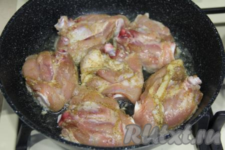 В сковороду влить растительное масло, хорошо его прогреть, после этого выложить куриные бёдра.