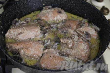 Томить кусочки курицы с грибами в сметане в течение 10 минут под крышкой на медленном огне, несколько раз за это время можно перевернуть бёдрышки.