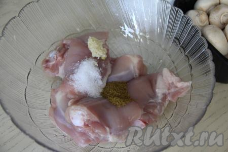 С куриных бёдер, по желанию, снять кожу. Выложить бёдра в миску, добавить к ним соль, специи (в качестве специй я использовала карри) и пропущенный через пресс чеснок.