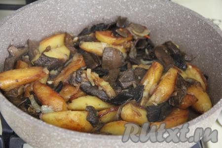 Жарить картошку с грибами на медленном огне минут 10-15 (картофель должен хорошо держать форму, но легко прокалываться вилкой), иногда перемешивая. В конце жарки посолить блюдо по вкусу, перемешать.