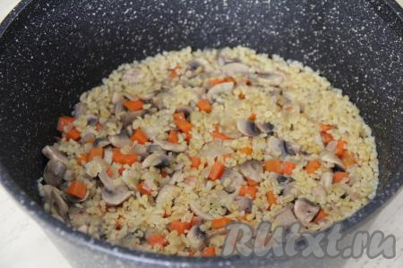 Довести воду до кипения, убавить огонь до минимума, накрыть крышкой. Готовить булгур с шампиньонами минут 25 (до полного испарения воды и мягкости булгура).