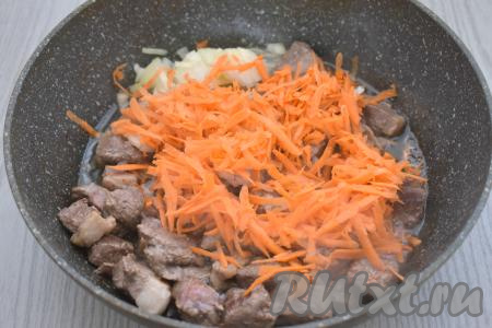 Лук и морковь очищаем. После того как кусочки утки обжарятся в течение 10 минут, добавляем в эту же сковороду мелко нарезанную луковицу и натёртую на крупной тёрке морковку. Перемешиваем утиное мясо с овощами. Обжариваем на среднем огне 5-6 минут, время от времени помешивая.