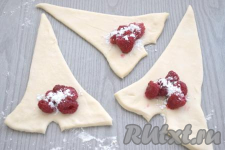 На треугольную заготовку, отступив от надреза и сторон треугольника, выкладываем 5-6 ягод малины. Ягоды посыпаем 0,5 чайной ложки кукурузного (или картофельного) крахмала и 1 чайной ложкой сахара.