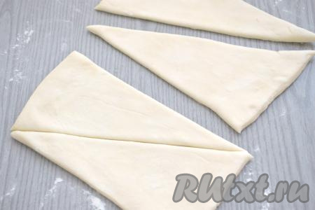 Раскатанное тесто делим на 2 равные половинки. Затем каждую половинку теста разрезаем по диагонали. В итоге у нас получаются 4 треугольные заготовки из теста.