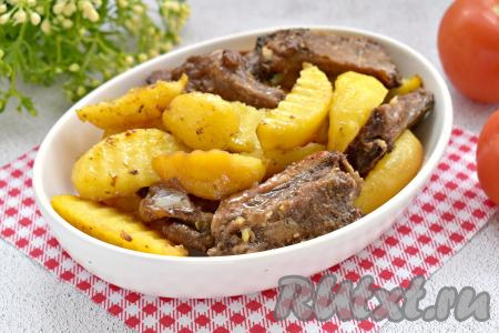 Готовое блюдо достаём из духовки. Свиные рёбра вместе с картошкой раскладываем по тарелкам и в качестве основного блюда подаём к столу. Благодаря соевому соусу, мясо получается сочным, нежным, картофель - аппетитным, в меру мягким. Очень вкусно и сытно, попробуйте!