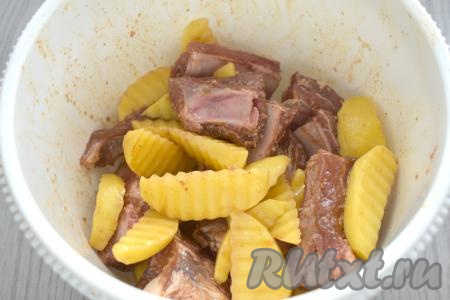 Тщательно перемешиваем картофель со свиными рёбрам и оставляем мариноваться ещё на 10 минут.