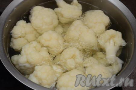 В кастрюли влить воду, выложить соцветия капусты. Вода должна полностью покрывать капусту. Поставить кастрюлю на огонь, посолить воду по вкусу. После закипания воды уменьшить огонь, варить капусту с момента закипания 7-8 минут. Цветная капуста должна легко прокалываться ножом, но при этом ещё хорошо держать форму, не разваливаться. Сразу слить всю воду из кастрюли и оставить капусту остывать.