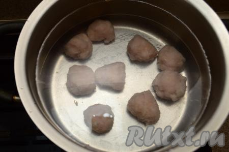 В кастрюлю влить 2,5 литра воды, выложить фрикадельки, поставить на огонь, довести до кипения.