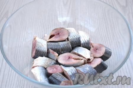 Нарезаем селёдку на кусочки шириной 1,5-2 сантиметра, перекладываем в глубокую миску.