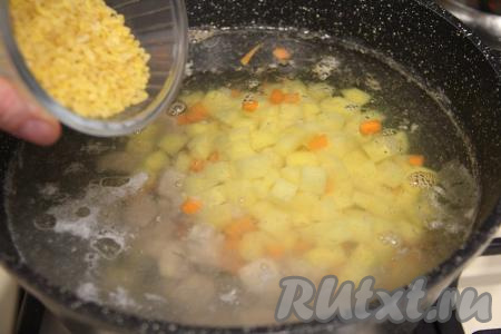 В кастрюлю со сварившейся свининой выложить картошку с морковью, всыпать булгур (предварительно промывать булгур не нужно).