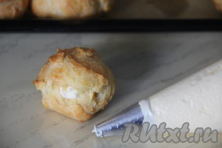 Наполнить остывшие профитроли пломбирным кремом.