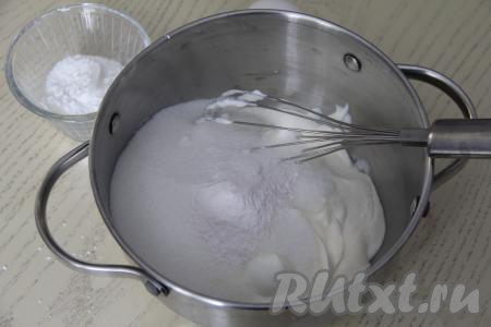 Приступаем к приготовлению заварной основы пломбирного крема. Для этого в кастрюлю с толстым дном нужно выложить сметану, всыпать сахар и ванильный сахар.