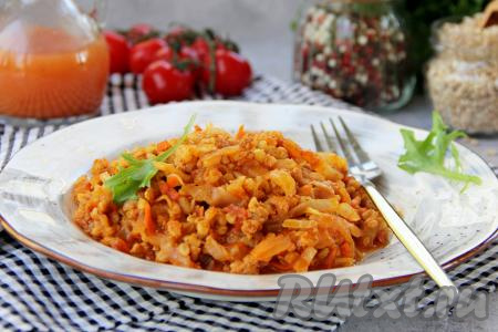 Разложить ленивые голубцы, приготовленные с капустой, перловкой и фаршем, по тарелкам и подать к столу в горячем виде.