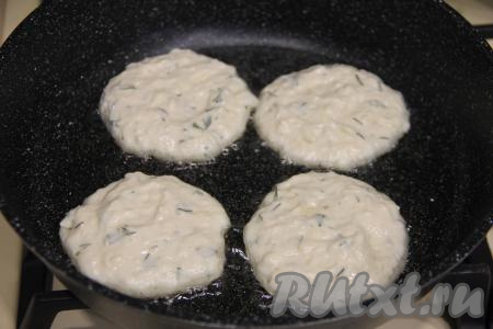 В сковороду влить растительное масло, хорошо разогреть на достаточно сильном огне. После этого уменьшить огонь до среднего, выкладывать по 1 столовой ложке сырного теста с зеленью в виде круглых оладий.&nbsp;
