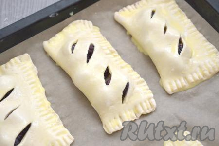 Сформированную слойку с ежевикой выкладываем на противень, застеленный пергаментом. Аналогично формируем ещё 3 слойки с ягодами, тоже выкладываем их на застеленный противень. В небольшой ёмкости (например, в стакане) яичный желток взбиваем до однородности с 1 столовой ложкой молока. Получившейся яично-молочной смесью смазываем наши слойки.