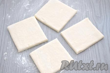 Стол присыпаем немного мукой, выкладываем пласт размороженного слоёного теста. Разрезаем тесто на 4 квадрата.