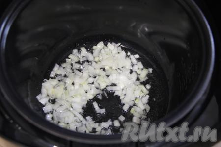 В чашу мультиварки влить растительное масло, добавить мелко нарезанный лук. Выставить на 15 минут режим "Жарка". Обжарить лук в течение 5 минут, периодически перемешивая.