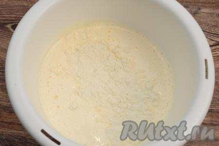 К взбитой яичной массе добавить разрыхлитель и часть просеянной муки. Полностью вмешать муку в тесто движениями лопатки снизу вверх. Вмешивая муку, старайтесь не сбить воздушной взбитой яичной массы. Продолжить понемногу добавлять оставшуюся просеянную муку, каждый раз полностью и аккуратно вмешивая её в бисквитное тесто.