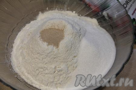 В миску всыпать 400 грамм просеянной муки, сахар и соль, добавить сухие дрожжи.