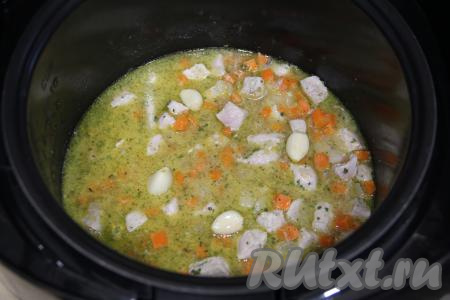 Перемешать булгур со свининой и солью, сверху выложить очищенные зубчики чеснока. Закрыть крышку мультиварки.