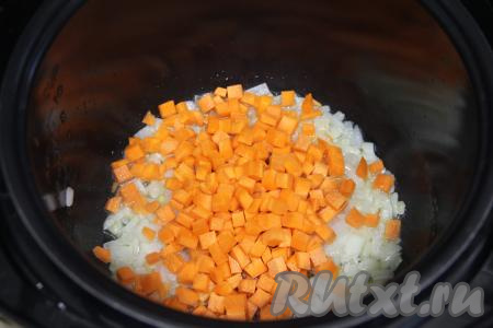 К обжаренному луку выложить морковку, нарезанную на небольшие кубики, перемешать, обжаривать овощи, время от времени помешивая, минут 5.