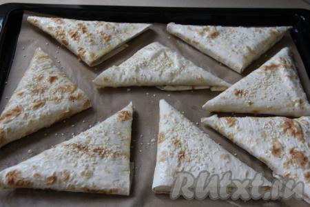 Яичный желток взбить вилкой в небольшой ёмкости. Смазать верх пирожков взбитым желтком и, по желанию, присыпать  кунжутом или маком.