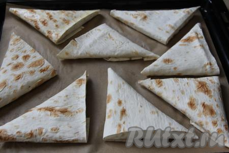 Таким же способом сформировать все треугольные пирожки из лаваша, выложить их на противень, застеленный пергаментом.
