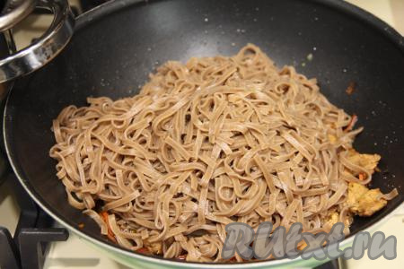 К индейке, протушившейся с овощами, добавить отваренную гречневую лапшу, перемешать.