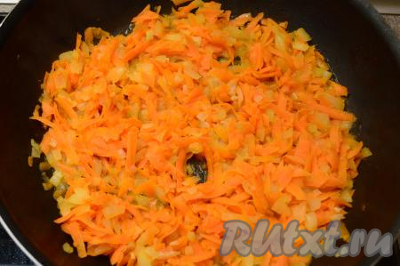К обжаренному луку выложить очищенную морковку, натёртую на крупной тёрке, перемешать, обжарить овощи в течение 5-6 минут (морковь должна стать достаточно мягкой). В процессе жарки не забывайте овощи периодически перемешивать, чтобы они не пригорели.