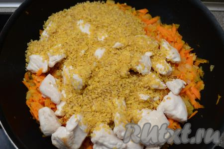 К обжаренным овощам выложить обжаренное куриное филе, всыпать булгур (предварительно промывать булгур не нужно).